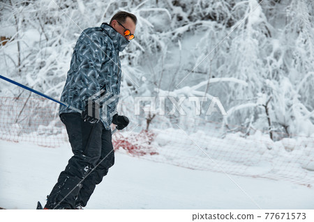 a skier in gray jacket is riding downhill the slope on a frosty day a skier in gray jacket is riding downhill the slope on a frosty day 77671573