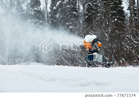 Snow cannon spraying out a fresh dusting of snow on the ski slopes. Snow cannon spraying out a fresh dusting of snow on the ski slopes. 77671574