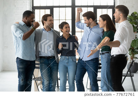 Excited motivated colleagues shouting for joy and celebrating team success Excited motivated colleagues shouting for joy and celebrating team success 77672761