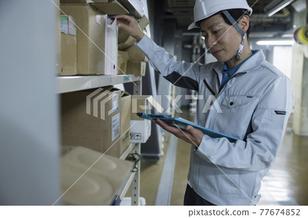 Male worker checking inventory in the factory 77674852