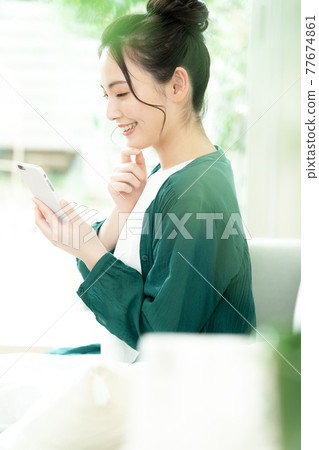 Young woman looking at a smartphone Young woman looking at a smartphone 77674861