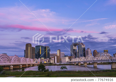 Skyscrapers around Osaka Station seen from the Yodogawa riverbed Cityscape Evening view 77674916