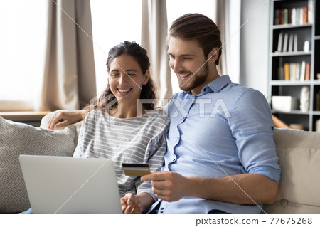 Smiling couple clients shopping online on laptop 77675268