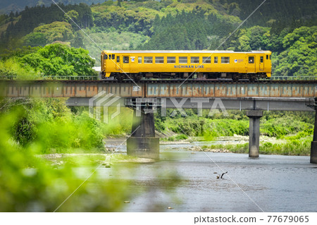 Kiha 40 on the Nichinan Line crossing an iron bridge over a river in the fresh green mountains Kiha 40 on the Nichinan Line crossing an iron bridge over a river in the fresh green mountains 77679065