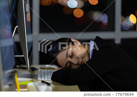 Asian lady call center worker employee sleeping on dest at night Asian lady call center worker employee sleeping on dest at night 77679694