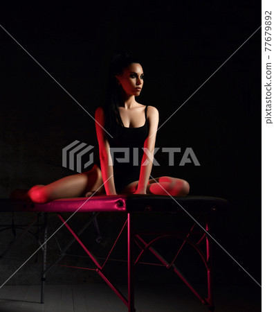 Young sexy brunette woman in black bodysuit sits Young sexy brunette woman in black bodysuit sits 77679892
