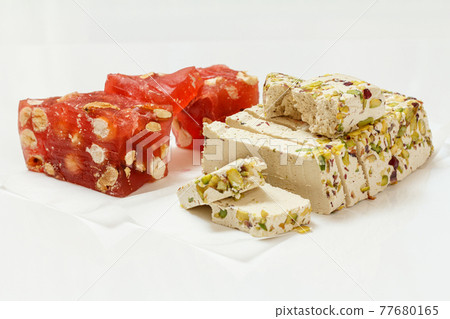 Fruit sweets and halva with nuts on white background. Fruit sweets and halva with nuts on white background. 77680165