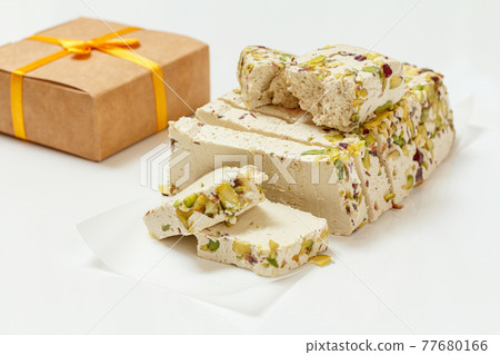 Halva with pistachios and gift box on white background Halva with pistachios and gift box on white background 77680166