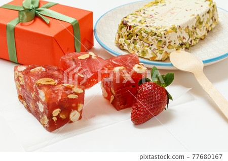 Fruit sweets with nuts and gift box on white background. Fruit sweets with nuts and gift box on white background. 77680167