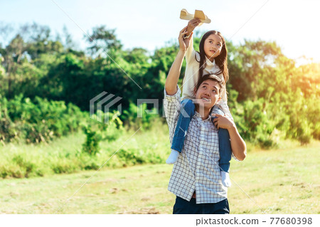 Daughter sits on his father's neck.The family enjoyed a holiday Holiday over beautiful nature.Concept People and family. Daughter sits on his father's neck.The family enjoyed a holiday Holiday over beautiful nature.Concept People and family. 77680398