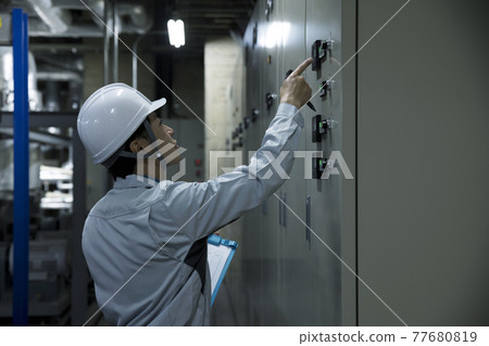 Male worker inspecting the factory Pointing confirmation 77680819