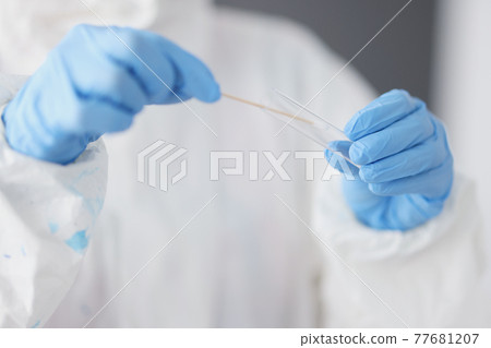 Researcher in protective suit and gloves holds test tube with smear of biological material 77681207
