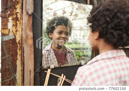 Little boy looking at mirror Little boy looking at mirror 77682188