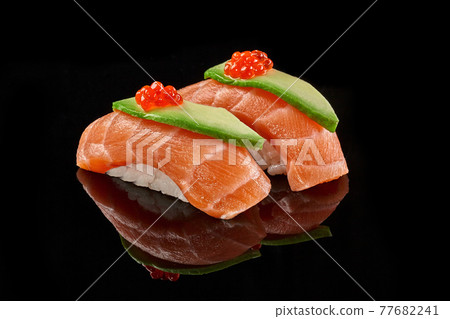 Two nigiri sushi with salmon, avocado, caviar on black background Two nigiri sushi with salmon, avocado, caviar on black background 77682241