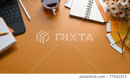Designer workplace with, notebook, coffee cup, color swatch and copy space on yellow leather. Designer workplace with, notebook, coffee cup, color swatch and copy space on yellow leather. 77682915
