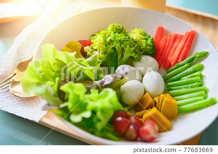 salad with vegetables and greens on wooden table salad with vegetables and greens on wooden table 77683669