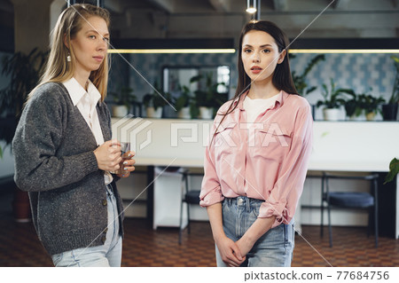 Two young women working together in office Two young women working together in office 77684756