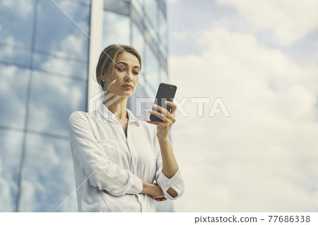 Businesswoman successful woman business person standing outdoor corporate building exterior. Pensive caucasian confidence professional business woman middle age Businesswoman successful woman business person standing outdoor corporate building exterior. Pensive caucasian confidence professional business woman middle age 77686338