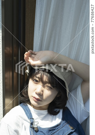 A woman relaxing at the window 77686427