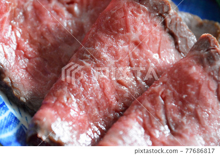 大理石牛肉切成薄片的烤牛肉和可樂牛肉在盤子上。 大理石牛肉切成薄片的烤牛肉和可樂牛肉在盤子上。 77686817