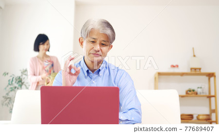 Senior male telework remote work to make online calls at home 77689407