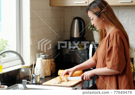 Woman making sandwiches 77689479