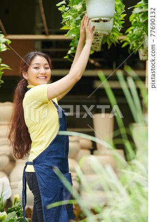 Woman working at gardening center Woman working at gardening center 77690132