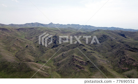 View of green hills and gorges with rocks. View of green hills and gorges with rocks. 77690552
