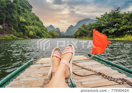 Woman tourist in Trang An Scenic Landscape Complex in Ninh Binh Province, Vietnam A UNESCO World Heritage Site. Resumption of tourism in Vietnam after quarantine Coronovirus COVID 19 Woman tourist in Trang An Scenic Landscape Complex in Ninh Binh Province, Vietnam A UNESCO World Heritage Site. Resumption of tourism in Vietnam after quarantine Coronovirus COVID 19 77690684