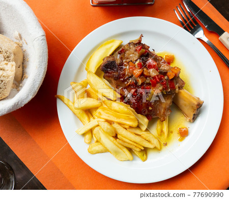 Pork baked shank with vegetables and french fries served Pork baked shank with vegetables and french fries served 77690990