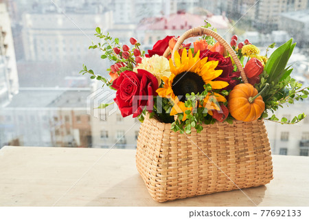 Mixed autumn flowers in basket, bouquet is on the windowsill with copy space. Mixed autumn flowers in basket, bouquet is on the windowsill with copy space. 77692133