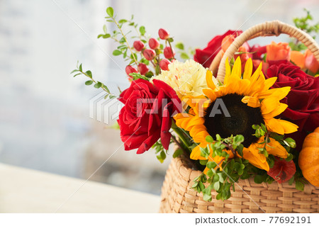 Mixed autumn flowers in basket, bouquet is on the windowsill with copy space. Mixed autumn flowers in basket, bouquet is on the windowsill with copy space. 77692191