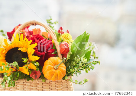 Mixed autumn flowers in basket, bouquet is on the windowsill with copy space. Mixed autumn flowers in basket, bouquet is on the windowsill with copy space. 77692345