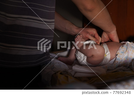 Father changes diaper to newborn son. Fatherhood Father changes diaper to newborn son. Fatherhood 77692348