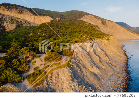 Aerial view of coastline with sea, mountains, canyon and cliffs with sunset light 77693202