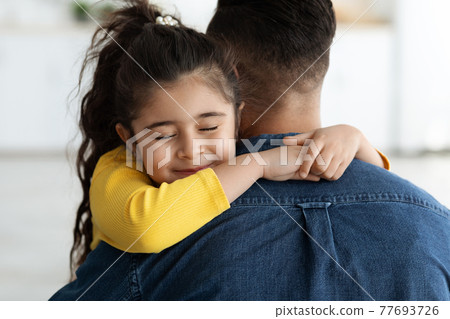 Father's Day Concept. Cute Little Arab Girl Hugging Her Dad At Home 77693726
