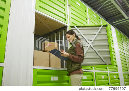 Worker standing in a warehouse Worker standing in a warehouse 77694507