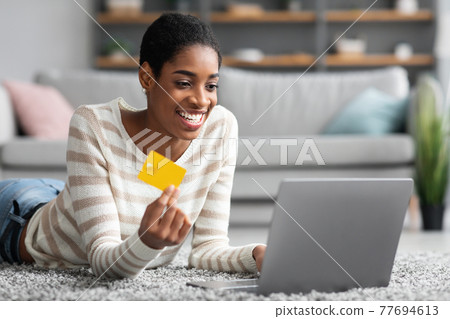 E-Commerce Concept. Happy Black Female Using Laptop And Credit Card At Home 77694613