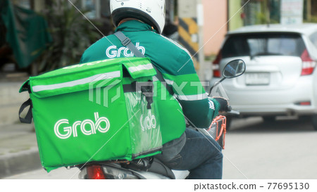 THAILAND OCT-16 : Grab food man is sending the food by motorcycle at the street to his customer, be serve job that very popular in Thailand, OCTOBER-16 2020 at Bangkok Thailand. THAILAND OCT-16 : Grab food man is sending the food by motorcycle at the street to his customer, be serve job that very popular in Thailand, OCTOBER-16 2020 at Bangkok Thailand. 77695130
