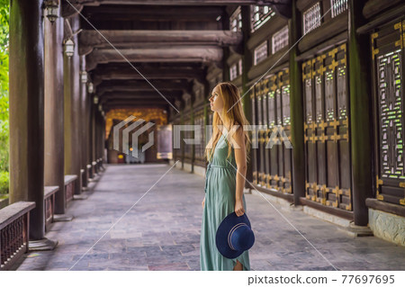 Woman tourist in Temple tower of Bai Dinh pagoda in Ninh Binh, Vietnam. Resumption of tourism in Vietnam after quarantine Coronovirus COVID 19 Woman tourist in Temple tower of Bai Dinh pagoda in Ninh Binh, Vietnam. Resumption of tourism in Vietnam after quarantine Coronovirus COVID 19 77697695