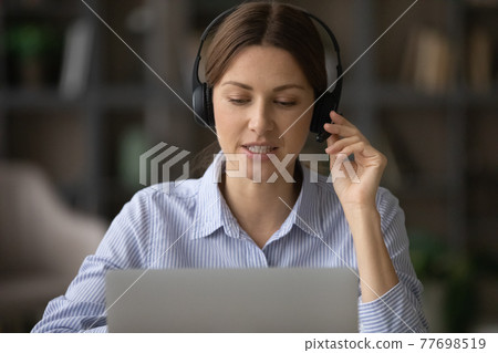 Confident millennial female client support assistant consult caller at workplace 77698519