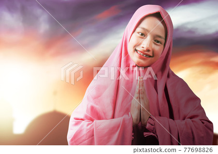 Asian Muslim woman in veil with greeting gesture Asian Muslim woman in veil with greeting gesture 77698826