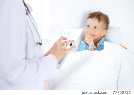 Happy smiling male kid-patient at usual medical inspection. Doctor and young boy in the clinic. Medicine concepts 77700727