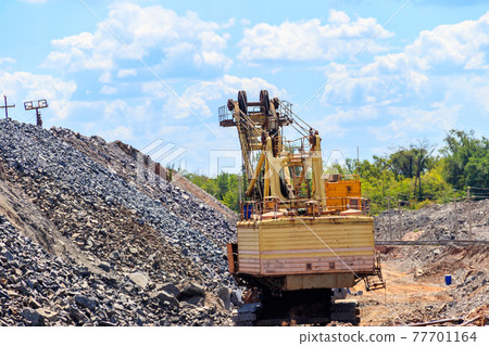 Big excavator working in iron ore quarry. Mining industry Big excavator working in iron ore quarry. Mining industry 77701164