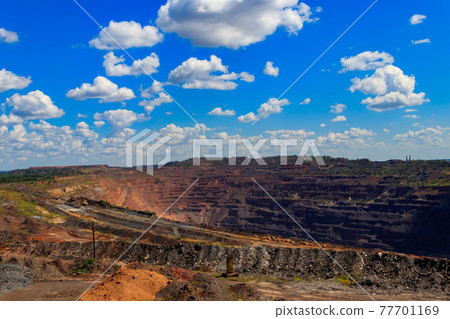 Huge iron ore quarry with working dump trucks and excavators in Kryvyi Rih, Ukraine Huge iron ore quarry with working dump trucks and excavators in Kryvyi Rih, Ukraine 77701169