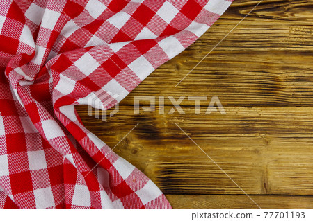 Red folded checkered napkin on rustic wooden kitchen table. Top view, copy space Red folded checkered napkin on rustic wooden kitchen table. Top view, copy space 77701193