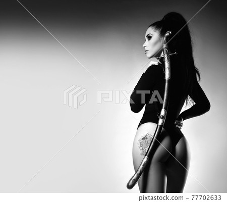 Black and white. Back view of young woman in 77702633