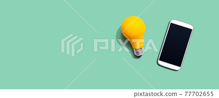 Smartphone with a yellow light bulb 77702655