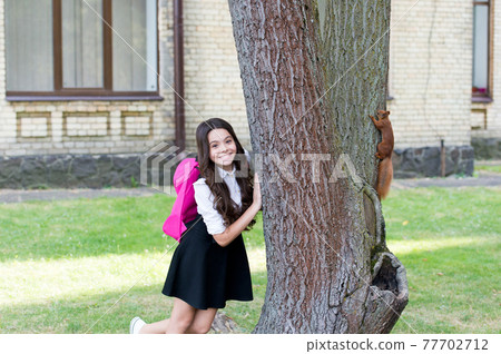 Happy little kid in school uniform with backpack observe 77702712