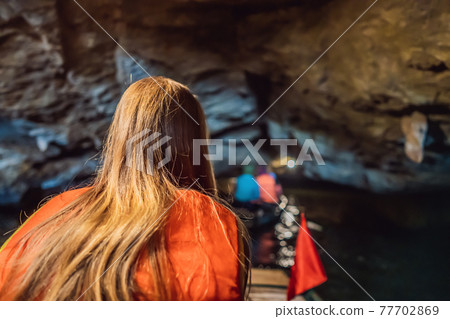 Woman tourist in Trang An Scenic Landscape Complex in Ninh Binh Province, Vietnam A UNESCO World Heritage Site. Resumption of tourism in Vietnam after quarantine Coronovirus COVID 19 77702869